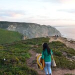 A Girl Climbing a Cliff near a beach