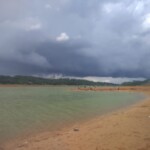 A Riverside View with Pristine Water and a Cloudy Sky
