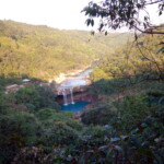 a distant view of a beautiful waterfall in the midst of a jungle