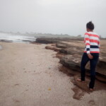 a woman walking on a sand beach
