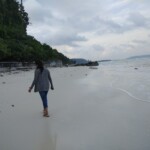 a woman walking on a sandy beach
