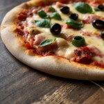 Pizza with basil and olive toppings