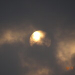 a rising full moon behind the clouds